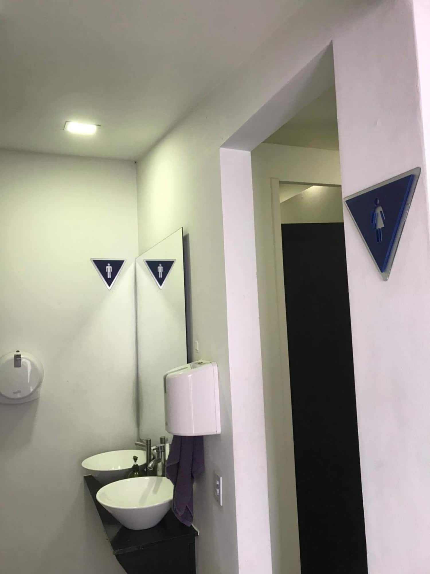 Entrada del baño compartido con lavamanos y espejo
