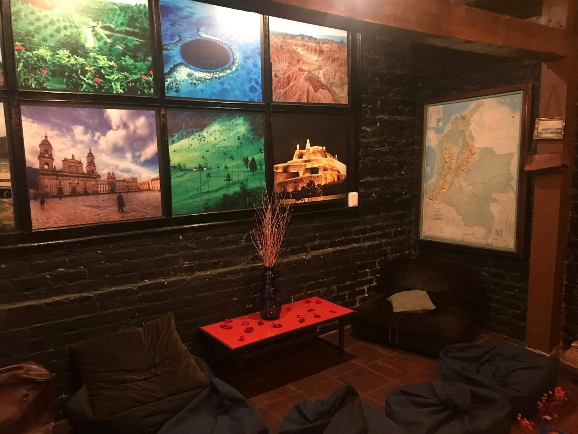 Sala con mesa roja, mapa de Colombia y fotos de paisajes