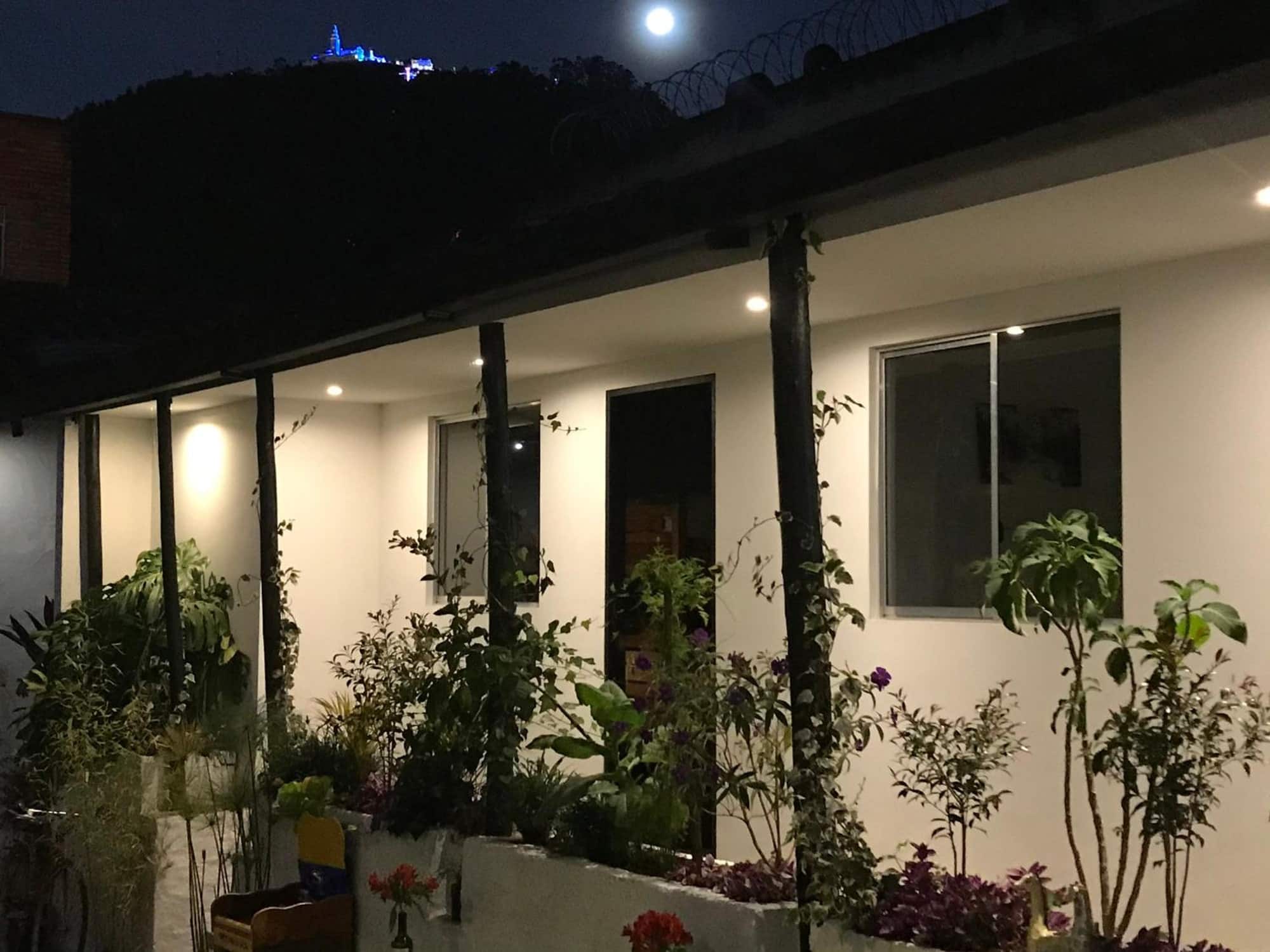 De noche: corredor iluminado y Monserrate encendido en el cerro