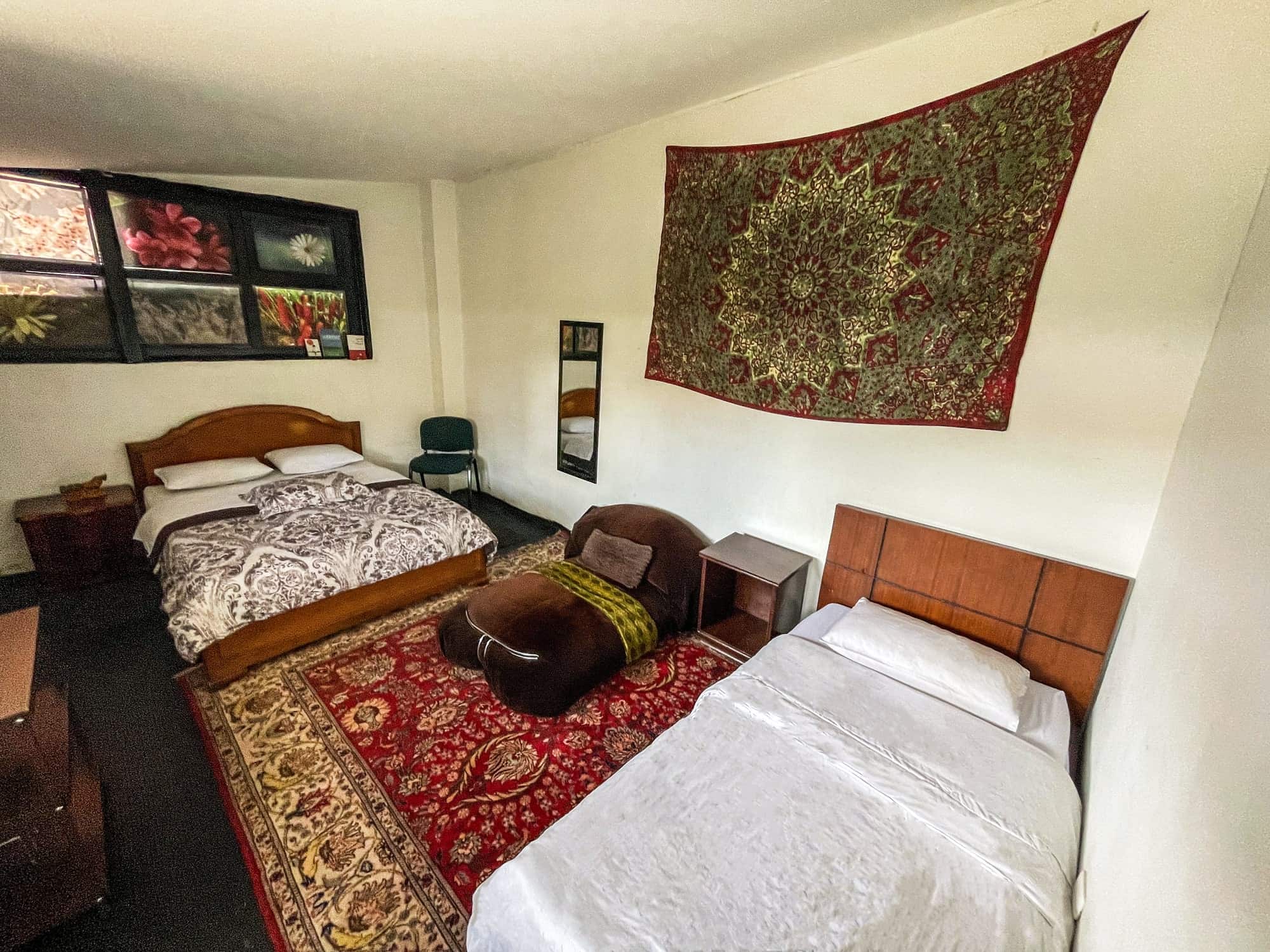 Habitación triple con cama doble y cama sencilla, tapete rojo