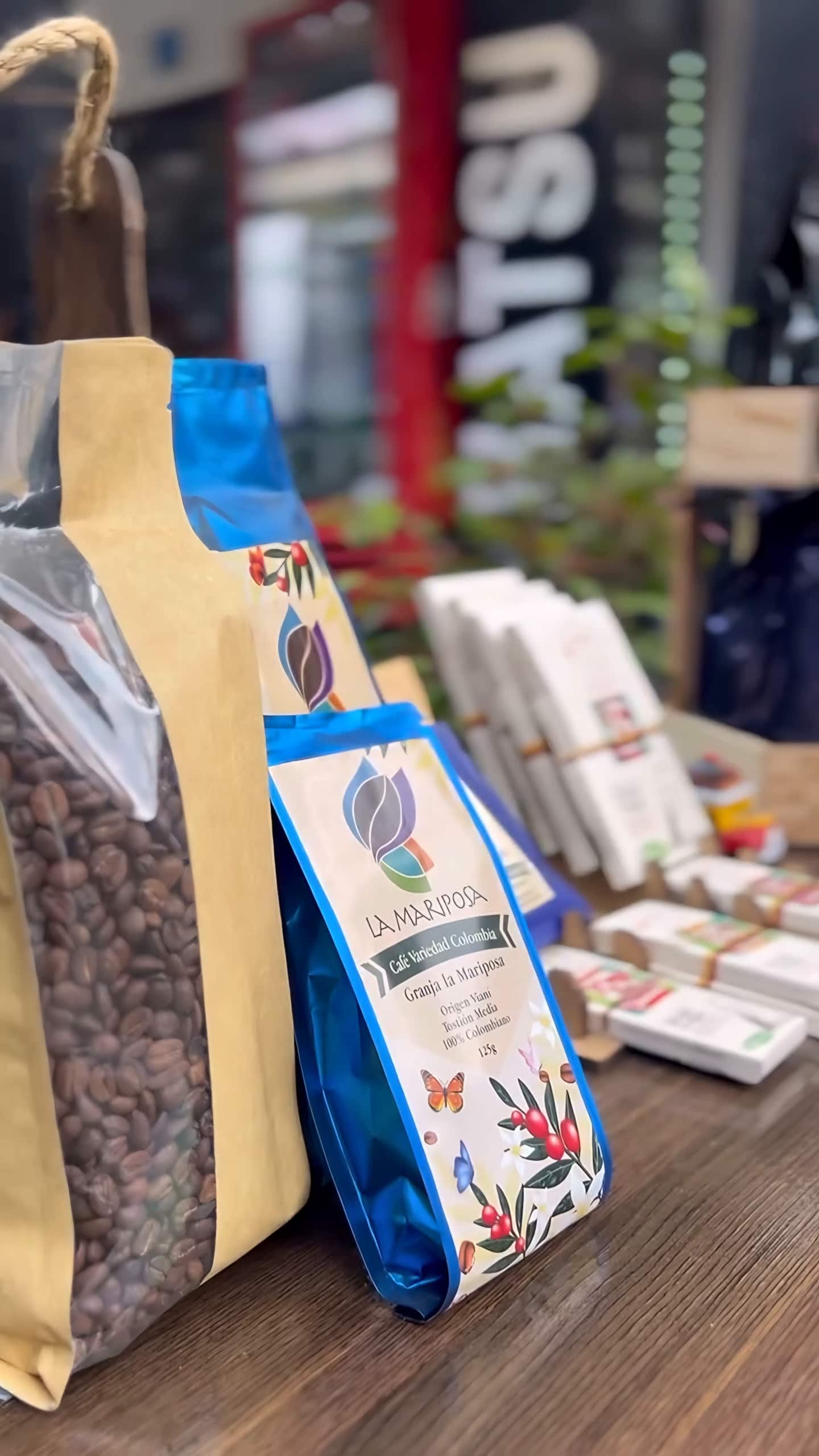 Bolsas de café y productos artesanales en una mesa durante la Feria Artesanal del hostal